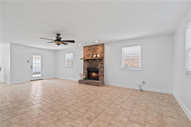 unfurnished living room with ceiling fan, baseboards, recessed lighting, a fireplace, and light tile patterned flooring