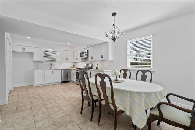 dining room with light tile patterned floors, recessed lighting, baseboards, and a chandelier