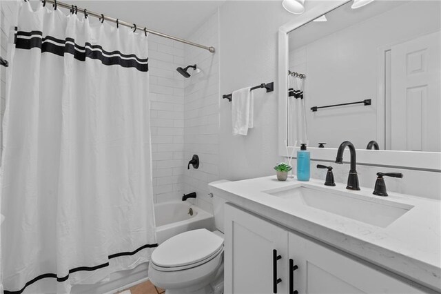 bathroom with vanity, toilet, and shower / bath combo with shower curtain