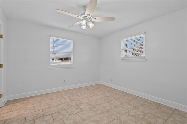 empty room featuring a ceiling fan and baseboards