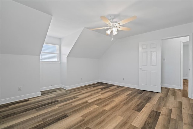 additional living space with lofted ceiling, wood finished floors, baseboards, and ceiling fan