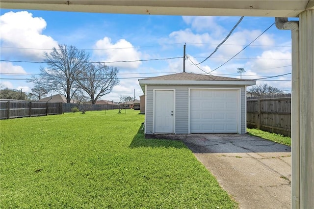 detached garage featuring fence and driveway