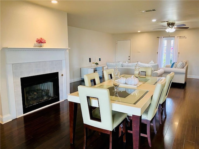 dining area with visible vents, a tiled fireplace, wood finished floors, recessed lighting, and baseboards