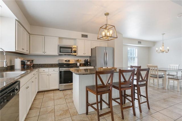 kitchen with visible vents, a notable chandelier, a sink, a center island, and stainless steel appliances