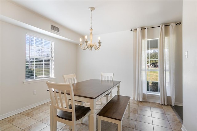 dining space featuring a notable chandelier, visible vents, baseboards, and light tile patterned floors