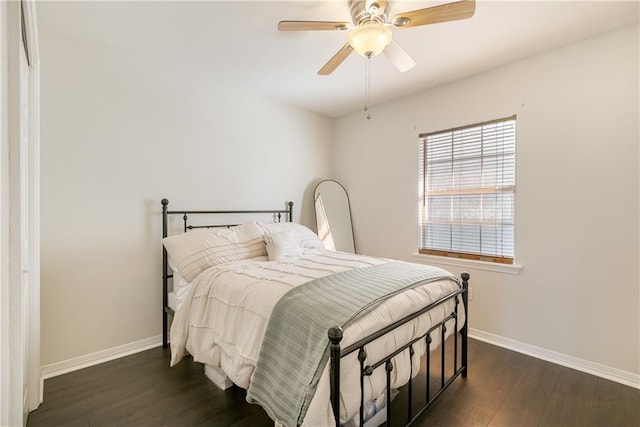 bedroom with dark wood finished floors, ceiling fan, and baseboards