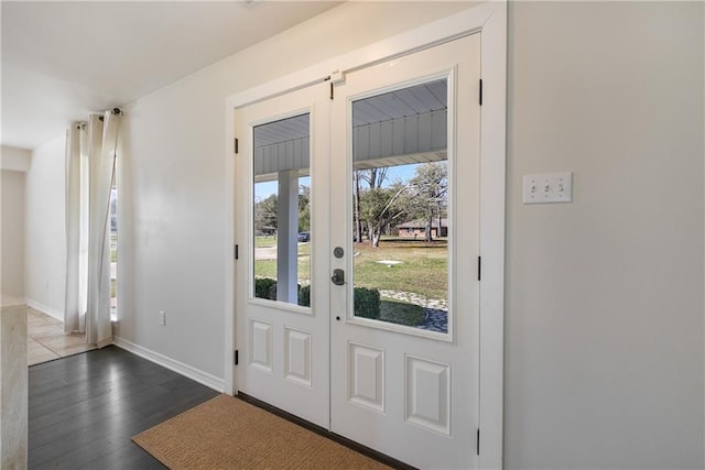 entryway with baseboards and wood finished floors