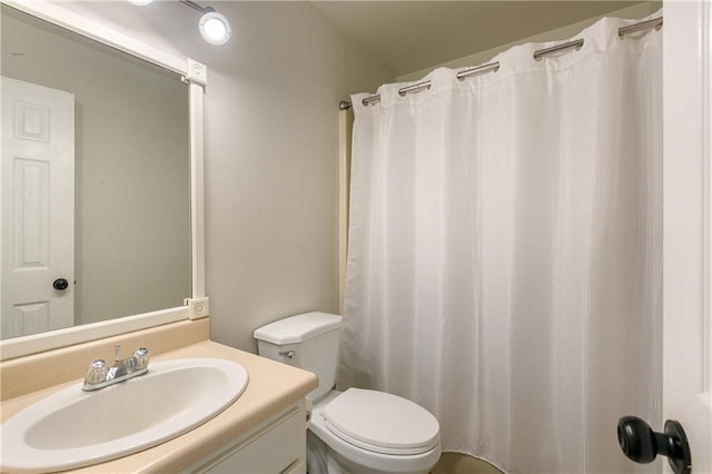 bathroom with vanity, a shower with shower curtain, and toilet