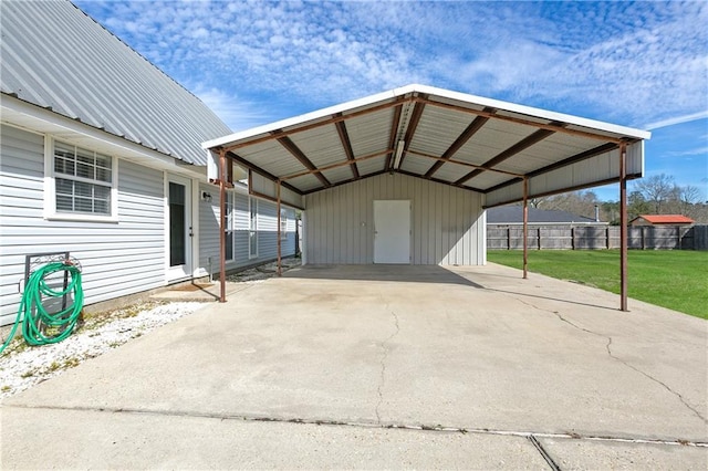 view of vehicle parking featuring a detached carport, driveway, and fence