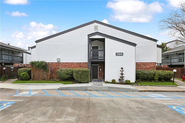 view of property featuring uncovered parking and fence