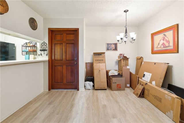 interior space featuring wood finished floors, a chandelier, and a textured ceiling