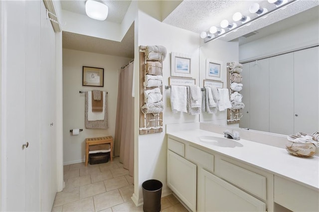 full bath with vanity, visible vents, tile patterned flooring, and a textured ceiling