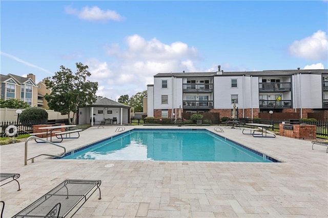 pool with a patio and fence