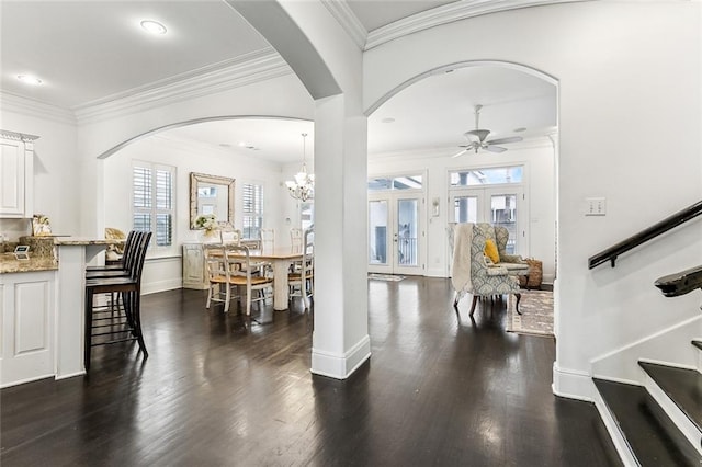 foyer entrance with stairway, dark wood-style floors, baseboards, ceiling fan, and crown molding