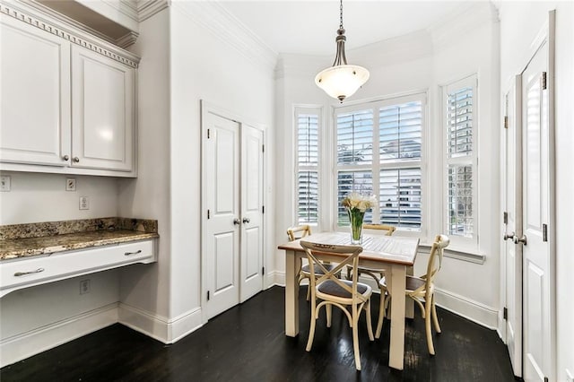 dining area featuring baseboards, built in desk, ornamental molding, and dark wood finished floors