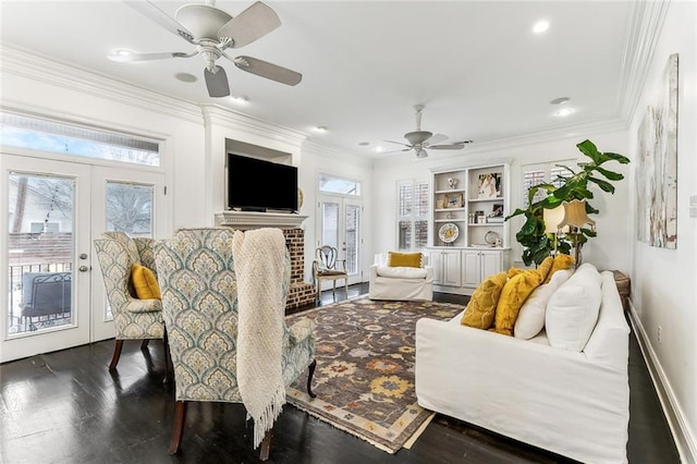 living area featuring plenty of natural light, french doors, crown molding, and dark wood-type flooring