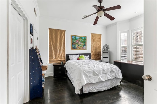 bedroom featuring a ceiling fan, wood finished floors, and crown molding