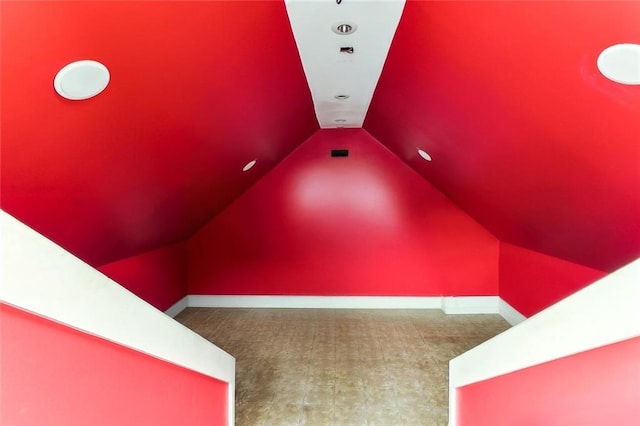 interior space featuring baseboards, carpet, and lofted ceiling