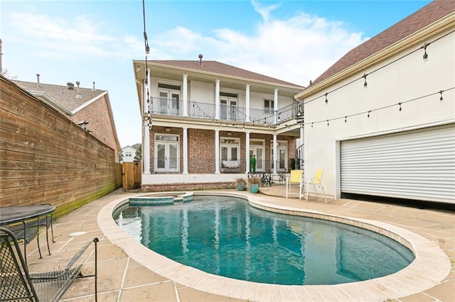 view of pool with a fenced backyard, french doors, a pool with connected hot tub, and a patio