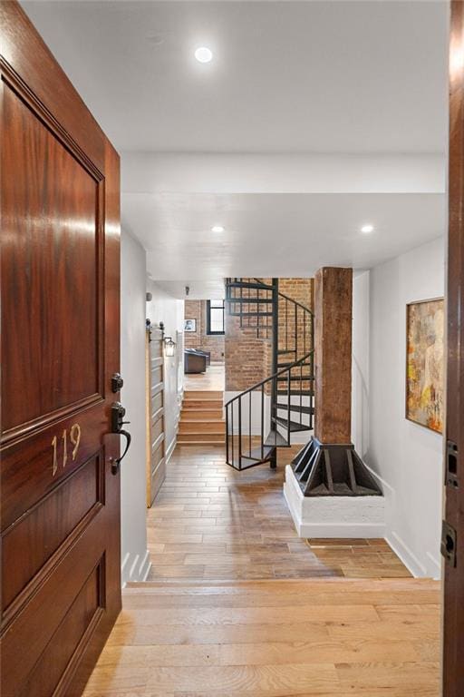 foyer with light wood finished floors, recessed lighting, stairs, and baseboards