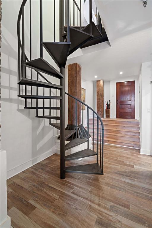 stairs featuring recessed lighting, wood finished floors, and baseboards