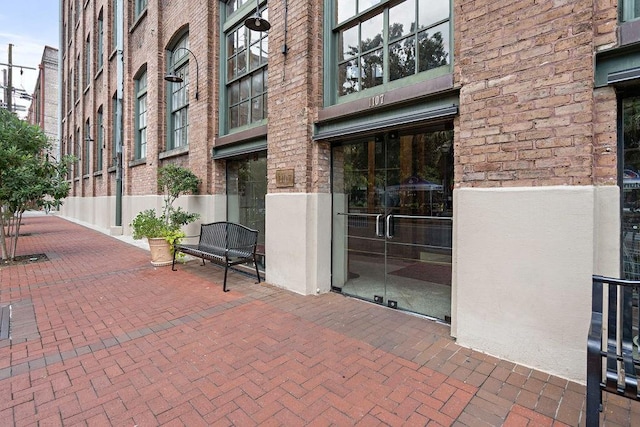 view of exterior entry featuring brick siding