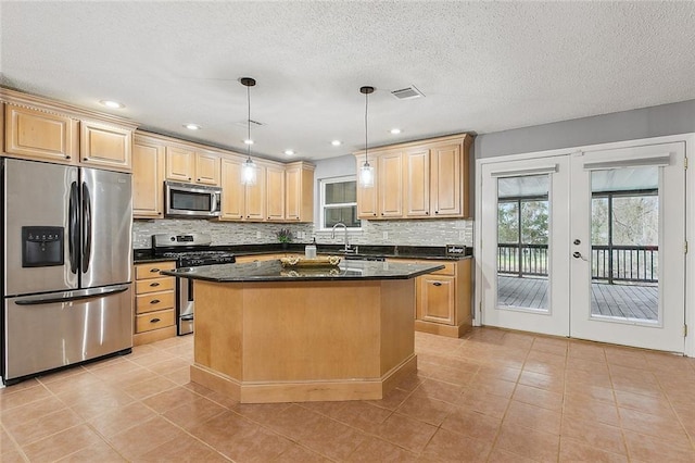 kitchen with visible vents, a kitchen island, french doors, appliances with stainless steel finishes, and backsplash