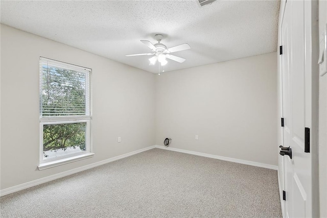 empty room with baseboards, carpet, and a textured ceiling