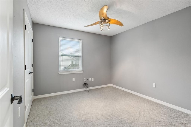 unfurnished room with carpet flooring, baseboards, and a textured ceiling