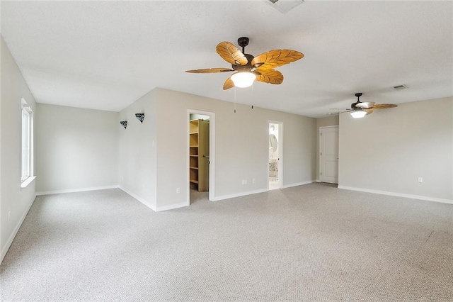 empty room with visible vents, light colored carpet, baseboards, and ceiling fan