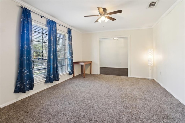 spare room featuring crown molding, a ceiling fan, visible vents, and carpet floors