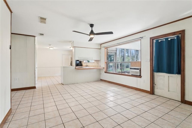 unfurnished living room featuring visible vents, baseboards, ornamental molding, and a ceiling fan