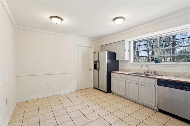 kitchen featuring a sink, stainless steel appliances, ornamental molding, and light countertops