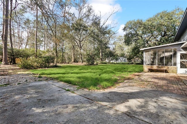 view of yard featuring a patio area and a sunroom