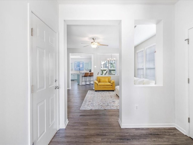 interior space featuring a chandelier, baseboards, and dark wood-style floors