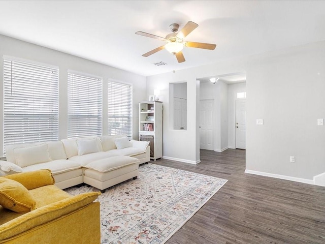 living room featuring dark wood finished floors, visible vents, a ceiling fan, and baseboards