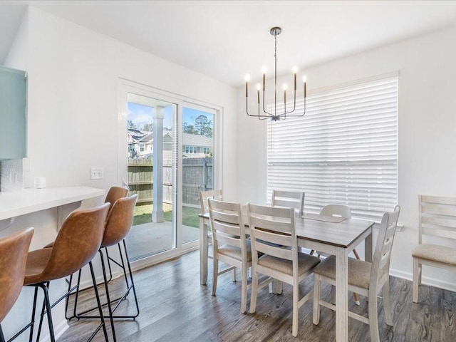 dining room with a chandelier, baseboards, and wood finished floors