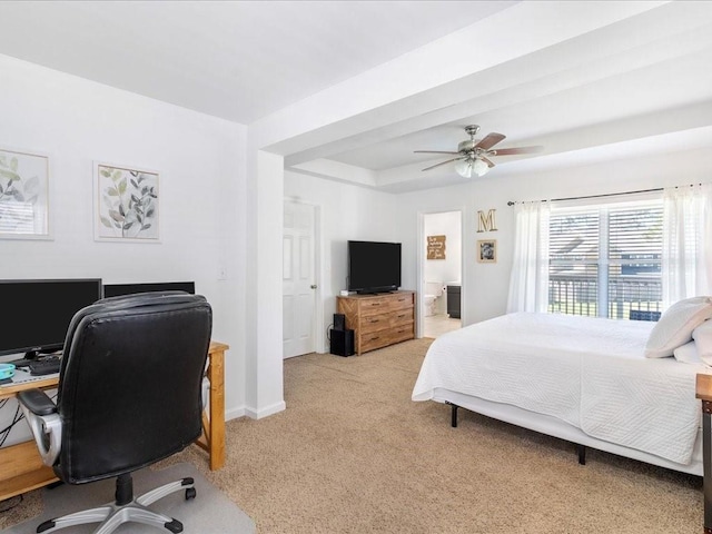 bedroom with a ceiling fan, baseboards, ensuite bath, light carpet, and a raised ceiling