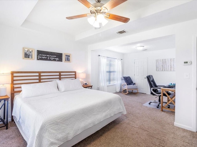 bedroom with visible vents, a raised ceiling, ceiling fan, and carpet floors