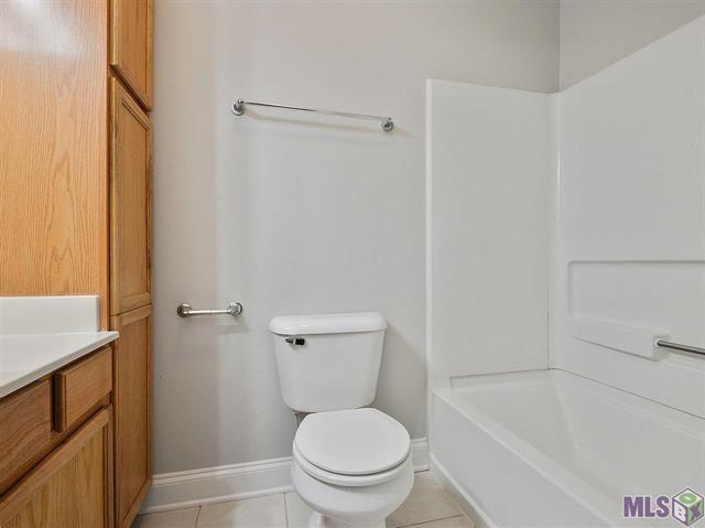 1500 Brightside Dr Unit D6, Baton Rouge, LA 70820 - full bath with baseboards, toilet, vanity, and tile patterned flooring