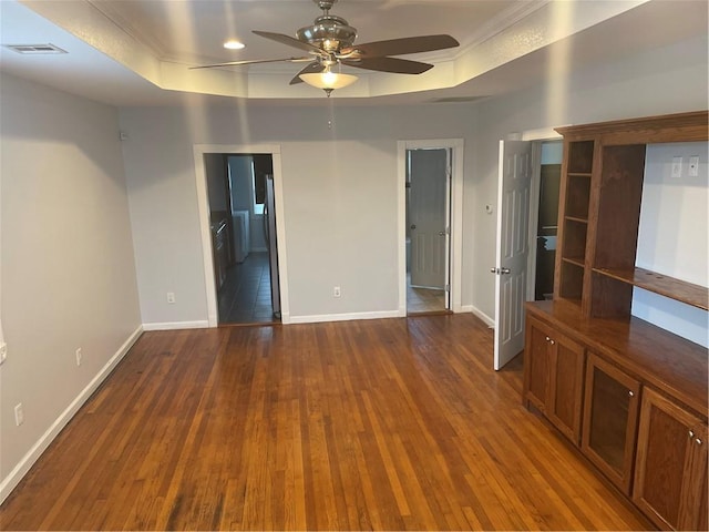 unfurnished room with hardwood / wood-style floors, a raised ceiling, and ceiling fan