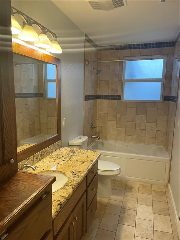 full bath featuring tile patterned flooring, visible vents, tub / shower combination, toilet, and vanity