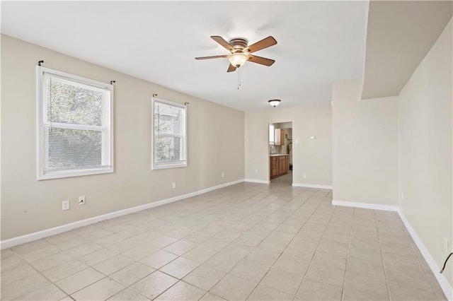 empty room with light tile patterned floors, baseboards, and ceiling fan