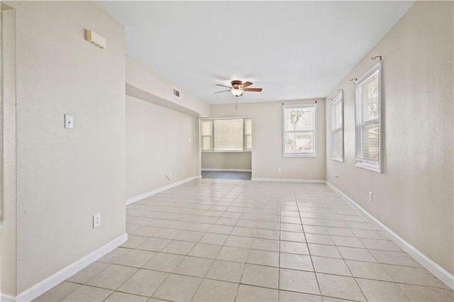 spare room with light tile patterned floors, visible vents, baseboards, and a ceiling fan