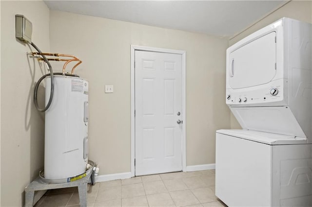 laundry area with laundry area, baseboards, electric water heater, and stacked washing maching and dryer