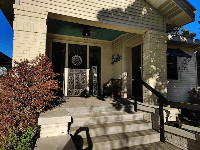 view of exterior entry featuring a ceiling fan and covered porch