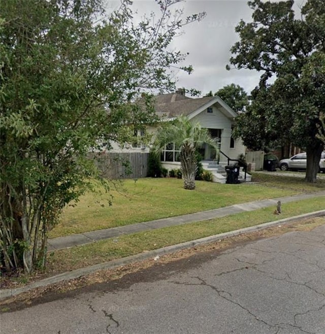 view of front of house with a front yard and fence