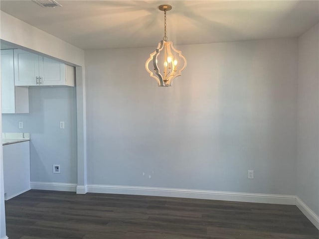 unfurnished dining area featuring visible vents, baseboards, a notable chandelier, and dark wood-style flooring