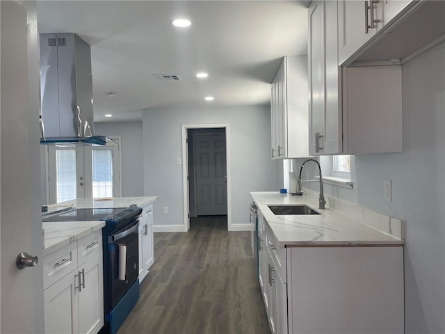 kitchen with visible vents, light stone countertops, island range hood, electric range, and a sink