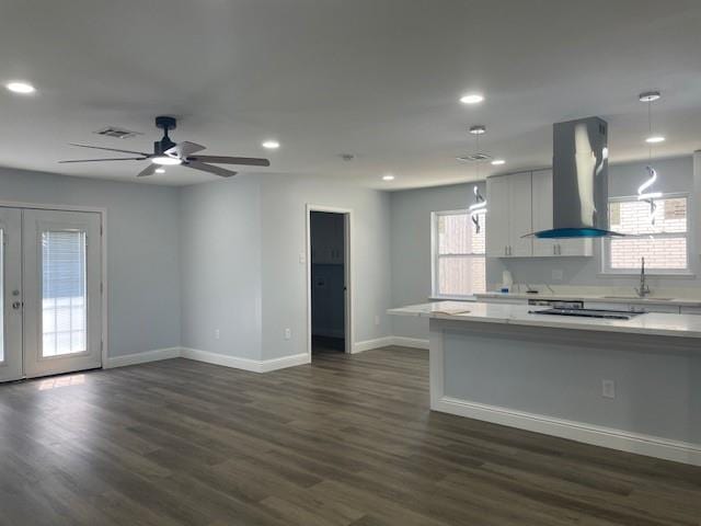 kitchen with dark wood finished floors, visible vents, light countertops, and island range hood